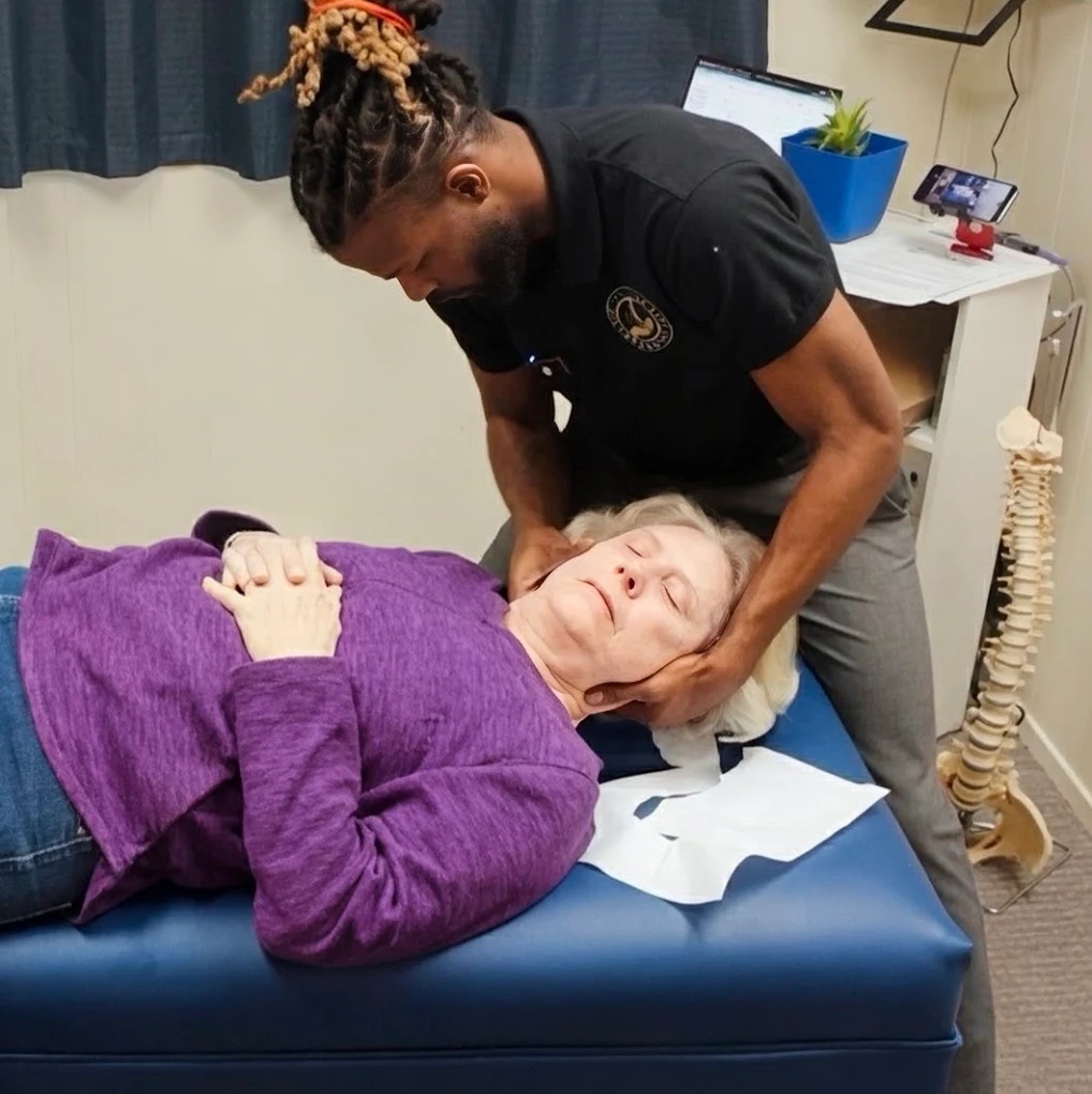 Dr. Kendell Jack performing a neck adjustment on a senior patient