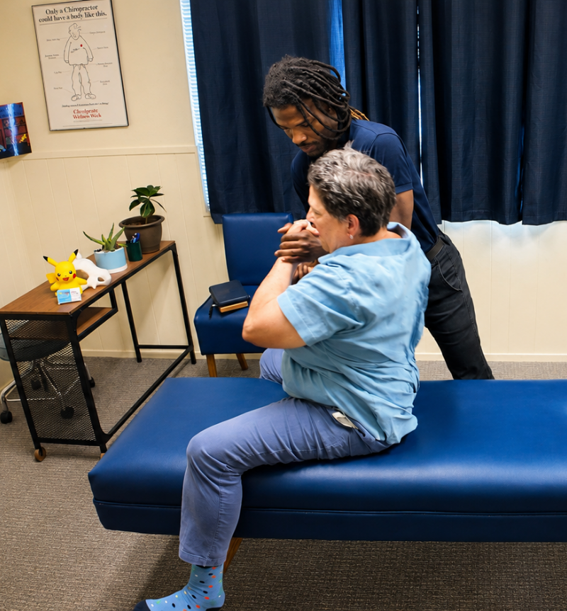 Dr. Kendell Jack performing an adjustment on a seated patient at Impulse Life Chiropractic