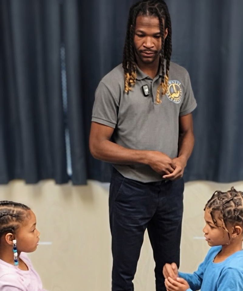 Dr. Kendell Jack talking with two children at a community event