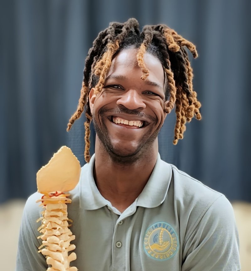 Dr. Kendell Jack smiling and holding a spine model